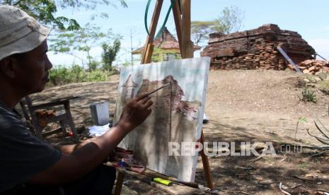 Juru kunci, Ahmad Saiful Munir melukis Candi Tawangalun yang ambruk, di Desa Buncitan, Sedati, Sidoarjo, Jawa Timur, Jumat (17/9/2021). Ambruknya sebagian candi yang juga dikenal dengan Candi Sumur Windu itu disebabkan karena ada masalah struktur pondasi tanah di sekitar candi mengalami retak. 