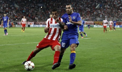 Juventus' Carlos Tevez (R) challenges Olympiakos' Omar Elabdellaoui during their Champions League soccer match at Karaiskaki stadium in Piraeus, near Athens, October 22, 2014.