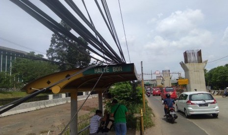 Kabel listrik di jalan raya Bekasi Jakarta, Cakung, Jakarta Timur menjuntai hingga ke trotoar jalan. 