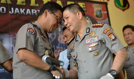 Kabid Humas Polda Metro Jaya Kombes Pol Argo Yuwono (kiri) berjabat tangan dengan Kapolres Metro Jakarta Barat Kombes Pol Roycke Harry Langie seusai memberikan keterangan terkait tahanan Polres Metro Jakarta Barat yang kabur di RS Polri Kramat Jati, Jakarta, Minggu (17/9). 