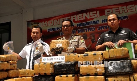 Kabid Humas Polda Metro Jaya Kombes Pol Argo Yuwono (tengah) didampingi Kasubdit I Ditresnarkoba AKBP Jean Calvijn Simanjuntak (kiri) menunjukan barang bukti saat rilis kasus penangkapan peredaran ganja di Polda Metro Jaya, Jakarta, Ahad (1/10). 