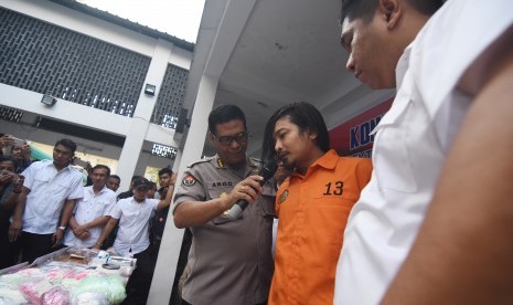 Kabid Humas Polda Metro Jaya Kombes Pol Argo Yuwono (ketiga kanan) berbincang dengan tersangka vokalis grup band Zivilia, Zulkifli alias Zul (kedua kanan) saat rilis pengungkapan kasus peredaran narkoba di Gedung Ditresnarkoba Polda Metro Jaya, Jakarta, Jumat (8/3/2019). 