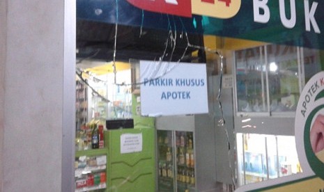 Kaca apotek retak terkena peluru yang ditembakan pencuri motor usai kepergok di Jl. Pondok Kopi Raya, Jakarta Timur, Rabu (22/4). 