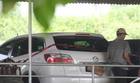 Kader PKS melintas usai menutupi plat nomor mobil Mazda CX9 B 2 MDF berwarna putih yang diduga milik Lutfhi Hasan Ishaaq disita KPK diparkir di halaman DPP PKS, Jakarta, Selasa (7/5).