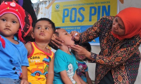 Kader Posyandu memberikan vaksin polio tetes pada salah satu anak peserta Pekan Imunisasi Nasional (PIN).