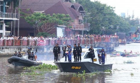 Kadispora Kalsel Zakly Asswan mengusung obor Asian Games 2018 di atas perahu motor Polairud Polda Kalsel dan TNI AL melintasi Sungai Martapura di Banjarmasin, Kalimantan Selatan, Senin (30/7)