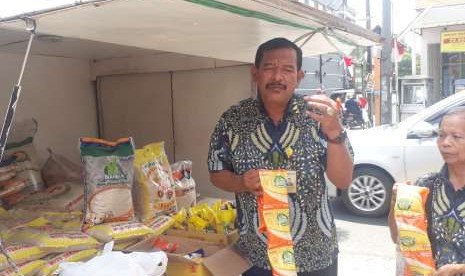 Kadivre Bulog Jabar Achmad Ma'mun, menunjukkan stok dan beras sachetan di Rumah Pangan Kita (RPK) Center Margacinta Kota Bandung, Kamis (23/8). Stok beras di Jabar masih aman untuk sembilan bulan ke depan.