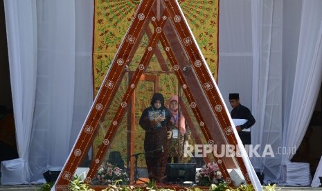  Kafilah dari Kalimantan Selatan, Yasni Prihati memasuki mimbar untuk melantunkan ayat suci Al Quran saat babak penyisihan MTQ Nasional ke XXVI cabang Sab’ah yang diselenggarakan di Islamic Center Kota Mataram, Nusa Tenggara Barat, Ahad (31/7).