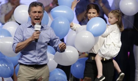 Kandidat presiden dari oposisi Argentina, Mauricio Macri (kiri) berbicara kepada pendukungnya di samping istri Juliana Awada dan putrinya Antonia saat merayakan kemenangannya dalam pemilu presiden di Buenos Aires, Argentina, Ahad, 22 November 2015. Macri a