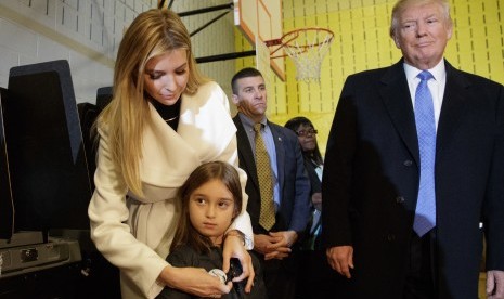 Kandidat presiden Donald Trump melihat putri Ivanka Trump memasangkan bros bertuliskan 'Saya Memilih' ke cucu Donald, Arabella, di TPS di New York, Rabu (9/11) waktu Indonesia.