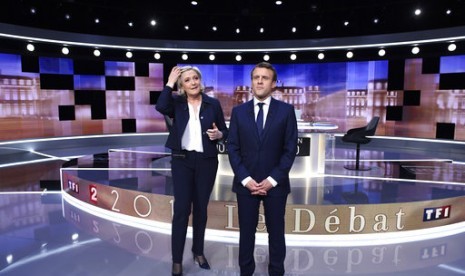 Kandidat presiden Prancis dari Partai National Front Marine Le Pen (kiri) dan Emmanuel Macron dari gerakan En Marche! Emmanuel Macron berpose sebelum memulai debat televisi terakhir di La Plaine-Saint-Denis, utara Paris, Rabu, 3 Mei 2017.