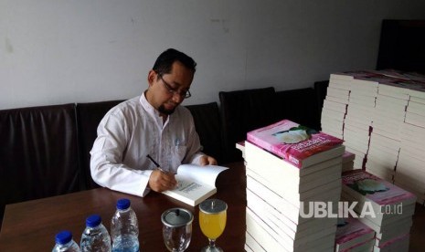 Habiburrahman El Shirazy menandatangani novel Bidadari Bermata Bening untuk pre order.