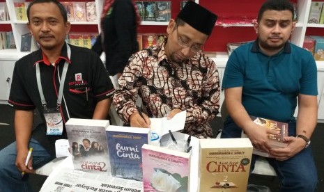 Kang Abik menandatangani novelnya.