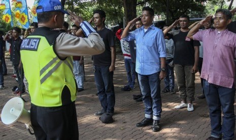 Kanit Pendidikan dan Rekayasa Satlantas Polres Jakpus AKP Antoni Wijaya (kiri) memberikan pelatihan kepada 'Pak Ogah' atau calon Sukarelawan Pengatur Lalu Lintas (supeltas) di Lapangan Banteng, Jakarta, Rabu (23/8). 