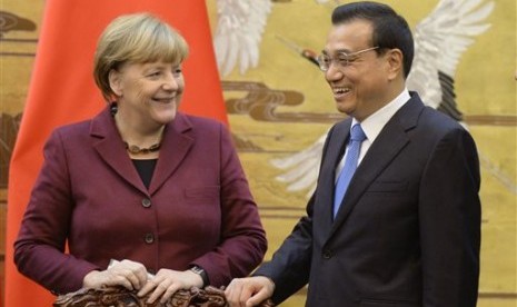 Kanselir Jerman Angela Merkel dan PM Cina Li Keqiang tersenyum usai menandatangani kesepakatan di Great Hall of the People di Beijing, Kamis, 29 Oktober 2015. 