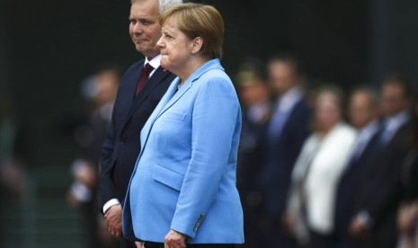 Kanselir Jerman Angela Merkel (kanan) dan Perdana Menteri Finlandia Antti Rinne mendengarkan lagi kebangsaan di Berlin, Jerman, Rabu (10/7). Merkel terlihat berusaha keras mengendalikan tubuhnya yang gemetar untuk ketiga kalinya di depan publik.