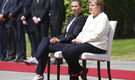 Kanselir Jerman Angela Merkel (kanan) dan tamu negara Perdana Menteri Denmark Mette Frederiksen duduk saat lagu nasional dinyanyikan dalam sebuah acara di Berlin, Jerman, Kamis (11/7).