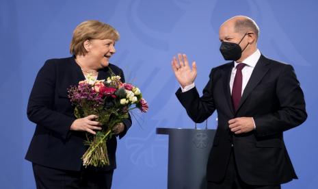 Kanselir Jerman yang baru terpilih Olaf Scholz, kanan, telah memberikan bunga kepada mantan Kanselir Angela Merkel selama upacara serah terima di kanselir di Berlin, Rabu, 8 Desember 2021.