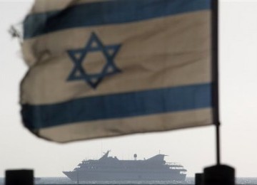 Kapal Mavi Marmara yang diserang Israel pada Mei tahun lalu, tampak di kejauhan, dengan latar depan bendera Israel.