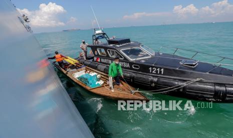 Kapal patroli Agensi Penguatkuasaan Maritim Malaysia (APMM) mengawal kapal pompong yang mengangkut dua orang nelayan asal Indonesia di perairan Malaysia, Senin (26/4/2021).