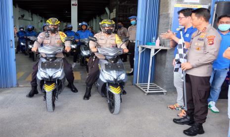 Kapolda Bali Irjen Pol Putu Jayan Danu Putra (kanan) menyaksikan sejumlah anggota polisi dan warga melakukan uji kendaraan motor listrik di Badung, Bali, Selasa (11/10/2022). Pihak swasta menyerahkan 100 kendaraan motor listrik kepada Pemerintah Provinsi Bali dan Polda Bali untuk operasional Presidensi G20 Summit guna mendukung transisi energi berkelanjutan yang menjadi salah satu isu prioritas dalam pelaksanaan Konferensi Tingkat Tinggi (KTT) G20 di Bali November mendatang. 