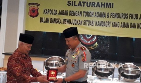 Kapolda Jabar, Irjen Pol Drs Agung Budi Maryoto menyerahkan cinderamata kepada Ketua FKUB Jabar, H Rafani Achyar.