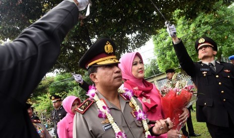 Kapolda Jawa Timur yang baru, Irjen Pol Machfud Arifin (kiri) didampingi istri Ny. Lita Machfud Arifin (kedua kiri) mengikuti prosesi pisah dan sambut di Mapolda Jawa Timur, Surabaya, Kamis (5/1).