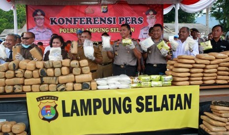 Kapolda Lampung Irjen Pol Purwadi Arianto (keempat kanan) didampingi Kapolres Lampung Selatan AKBP M Syarhan (ketiga kiri) beserta Forkompinda Lampung Selatan menunjukkan barang bukti ganja, sabu-sabu dan ekstasi saat rilis kasus dan pemusnahan barang bukti di lapangan rumah dinas Polres Lampung Selatan, di Lampung, Selasa (12/3/2019). 