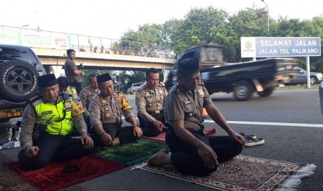 Kapolres Cirebon Kota, AKBP Adi Vivid Agustiadi Bahtiar dan sejumlah jajarannya melaksanakan shalat Ashar di baju halan tol Palikanci, Cirebon, Jawa Barat, Jumat (30/6), di tengah kesibukan mereka mengatur arus balik lebaran menuju Jakarta.