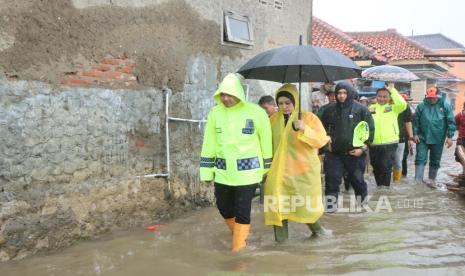 Kapolres Indramayu, AKBP Ari Setyawan Wibowo, didampingi Ketua Bhayangkari Cabang Indramayu, Rini Ari Setyawan, meninjau lokasi banjir rob di Desa Eretan Kulon, Kecamatan Kandanghaur, Kabupaten Indramayu, Rabu (29/1/2025). 