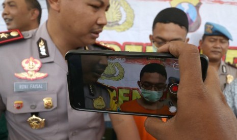 Kapolres Kediri AKBP Roni Faisal (kiri) menginterogasi tersangka mucikari prostitusi anak berinisial LP saat gelar kasus di Polres Kediri, Jawa Timur, Jumat (2/8/2019). 