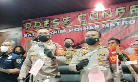 Kapolres Metro Jakarta Barat Kombes Ady Wibowo (kiri) memperlihatkan barnag bukti senjata api jenis revolver, yang digunakan pelaku untuk menembak seorang remaja Taman Sari, di Mapolres Jakbar, Kamis (24/6).