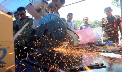 Kapolres Palu AKBP Trisno Rahmadi memotong senpi rakitan hasil sitaan di di kantor Kejaksaan Negeri Palu, Rabu (1/10).