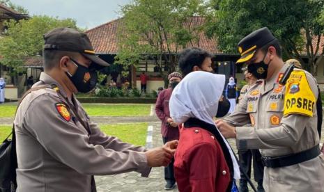 Kapolres Semarang, AKBP Yovan Fatika HA menyematkan pin tanda Satgas Jalur Sekolah kepada salah seorang siswa, pada peluncuran program Jaga Sedulur di Sekolah (Jalur Sekolah) di SMAN 2 Ungaran, Kabupaten Semarang, Kamis (25/11). Dukung pencegahan kalster penularan Covid-19 di sekolah, Polres Semarang meluncurkan program ‘Jalur Sekolah’ di sekolah tersebut.