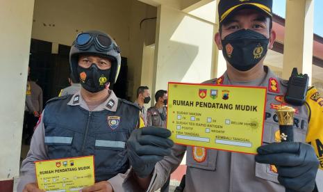 Kapolres Semarang, Yovan Fatika HA menunjukan stiker yang wajib ditempel rumah warga yang keluarganya mudik di wilayah Kabupaten Semarang, usia apel gelar pasukan Operasi Lilin Candi 202q di Unharan, Kabupaten Semarang, Kamis (23/12). Stiker ini digunakan untuk melakjkam pendataan jumlah warga Kabupaten Semarang yang mudik pada libur Natal dan Tahun Bafu kali ini.