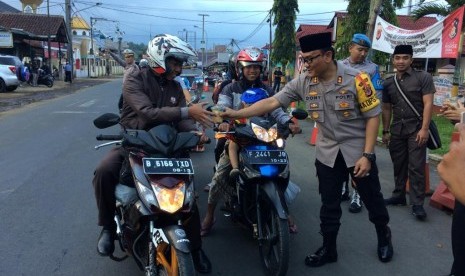 Kapolres Tasikmalaya AKBP Doni Eka Putra dan para polwan membagikan takjil ke pengendara yang melintas di Jalan Mangunreja, Kecamatan Singaparna, Kabupaten Tasikmalaya, Rabu (8/5). 