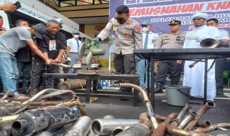 Kapolres Tasikmalaya Kota, AKBP Aszhari Kurniawan, memotong knalpot bising yang disita aparat kepolisian, di Markas Polres Tasikmalaya Kota, Kamis (22/9/2022). 