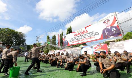 Kapolresta Banyuwangi Kombes Pol Deddy Foury Millewa menyiramkan air bunga anggotanya pada upacara kenaikan pangkat di halaman Mapolresta Banyuwangi, Jawa Timur, Senin (4/7/2022). Sebanyak 77 anggota Polresta Banyuwangi yang pangkatnya dinaikan satu tingkat mengikuti tradisi tersebut. 