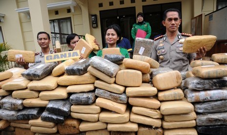 Kapolresta Depok Kombes (Pol) Dwiyono (kanan) bersama Kasat Narkoba Kompol Vivick Tjangkung (kedua kanan) menunjukkan barang bukti ratusan bal ganja kering berikut tersangka saat gelar perkara di Mapolresta Depok, Jawa Barat, Kamis (19/11).