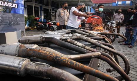 Kapolresta Sidoarjo Kombes Pol Kusumo Wahyu Bintoro (kiri) menyaksikan pemusnahan knalpot yang tidak standar atau brong hasil razia balap liar motor di halaman Polresta Sidoarjo, Jawa Timur, Senin (8/11/2021). Satuan Lalu lintas Polresta Sidoarjo berhasil mengamankan sebanyak 142 kendaraan bermotor yang diduga digunakan dalam aksi balap liar motor di akses jalan exit tol porong pada Minggu (7/11) dini hari. 