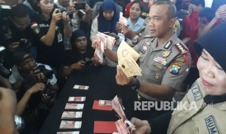 Kapolrestabes Surabaya Kombes Pol Rudi Setiawan menunjukkan barang bukti dan para tersangka dugaan penjualan, peredaran, dan kepemilikan uang palsu, di Mapolrestabes Surabaya, Selasa (27/3).