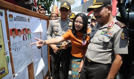 Kapolri Jenderal Pol Badrodin Haiti (kanan) dan Kapolresta Depok Kombes Dwiyono (kiri) menyimak penjelasan Ketua KPUD Depok Titik Nurhayati (tengah) saat meninjau proses pemungutan suara di TPS Kampung Pilkada RW 03, Depok Jaya, Depok, Jawa Barat, Rabu (9/