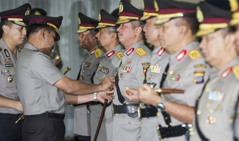 Kapolri Jenderal Pol Badrodin Haiti (kiri) memasang lencana jabatan kepada para Perwira Tinggi (Pati) Polri yang dimutasi dalam upacara sertijab di Mabes Polri, Jakarta, Kamis (21/4).