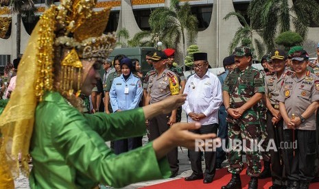 Kapolri Jenderal Pol. M Tito Karnavian (kanan) bersama Panglima TNI Marsekal TNI Hadi Tjahjanto (ketiga kanan), Kapolda Riau Irjen Pol Nandang (kedua kanan), dan Plt Gubernur Riau Wan Thamrin Hasyim (keempat kanan) disambut tarian setibanya di halaman Kantor Gubernur Riau, Pekanbaru, Riau, Jumat (20/4). 