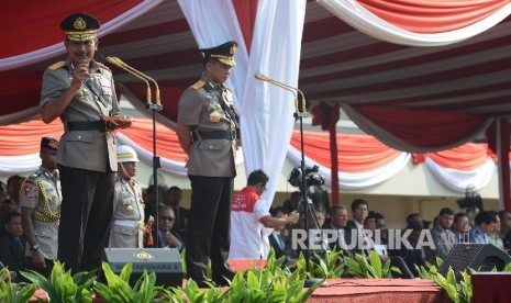 Kapolri Jenderal Pol Tito Karnavian (kanan) bersama mantan Kapolri Jenderal Pol Badrodin Haiti (kiri) memberikan kata sambutan saat mengikuti serah terima jabatan Kapolri di Lapangan PTIK, Jakarta, Kamis (14/7)