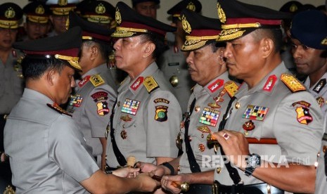 Kapolri Jenderal Pol Tito Karnavian (kiri) memberikan tongkat komando kepada Pejabat baru Kapolda Metro Jaya, Irjen Pol Idham Azis (kedua kanan) saat serah terima jabatan Kapolda Metro Jaya di Mabes Polri, Jakarta, Rabu (26/7).