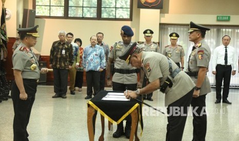 Kapolri Jenderal Pol Tito Karnavian (kiri) menyaksikan Kapolda Papua Irjen Pol Paulus Waterpauw (tengah) membubuhkan tanda tangan disaksikan pejabat lama Irjen Pol Rudolf Albert Rodja saat upacara sertijab di Mabes Polri, Jakarta, Senin (30/9/2019). 