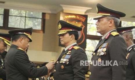 Kapolri Jenderal Pol Tito Karnavian (kiri) menyematkan tanda pangkat kepada Wakapolri Komjen Pol Ari Dono Sukmanto (tengah) dan Kabareskrim Komjen Pol Arief Sulistyanto (kanan) saat pelantikannya di Mabes Polri, Jakarta, Jumat (17/8).