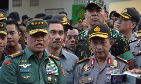 Kapolri Jenderal Tito Karnavian (kanan) bersama Panglima TNI Jenderal Gatot Nurmantyo (kiri) memberikan keterangan kepada wartawan usai melihat langsung dua teroris yang tewas tertembak di Palu, Sulawesi Tengah, Rabu (20/7). 