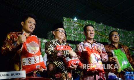 Kapolri Jenderal Tito Karnavian (kedua kiri) bersama Menteri Pertanian Amran Sulaiman (kedua kanan), Ketua Komisi Pengawas Persaiangan Usaha (KPPU) Syarkawi Rauf (kiri) dan Sekjen Kementerian Perdagangan Karyanto (kanan) menunjukkan karung berisi beras yang dipalsukan kandungan karbohidratnya dari berbagai merk saat penggerebekan gudang beras di PT Indo Beras Unggul, di kawasan Kedungwaringin, Kabupaten Bekasi, Jawa Barat, Kamis (20/7) malam. 